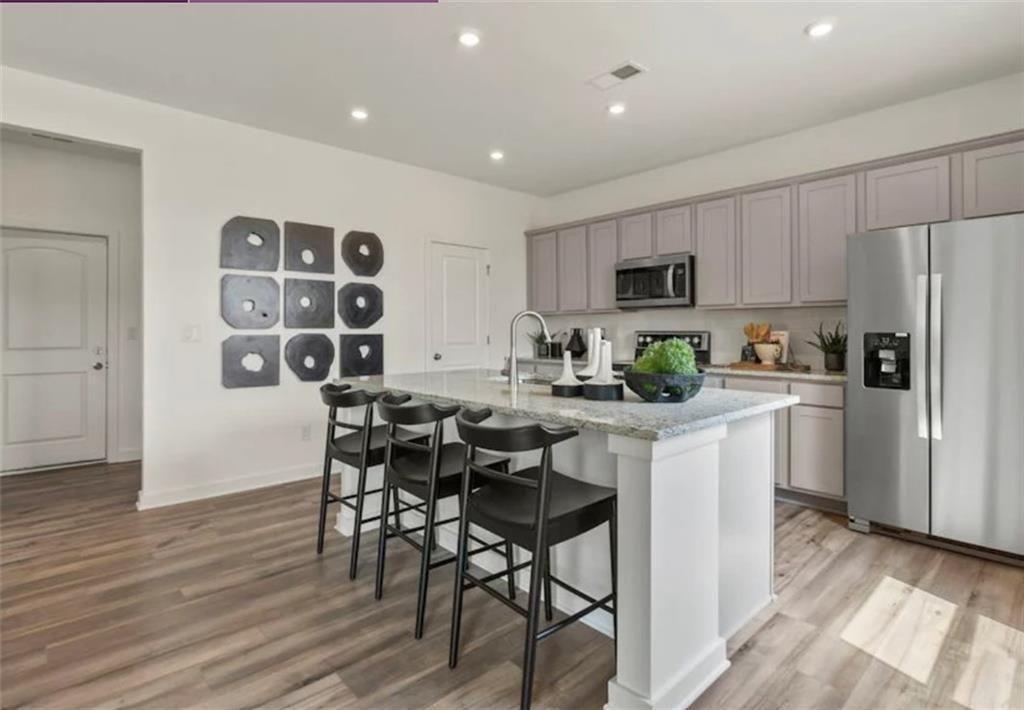 74 Poplar Blf Way Jefferson, GA 30549 - Photo 12 of 32 a kitchen with a table chairs refrigerator and microwave