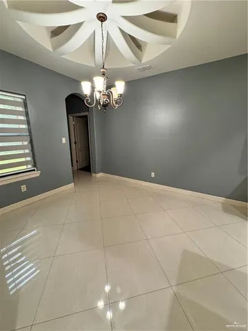 a view of a livingroom with a chandelier fan and windows