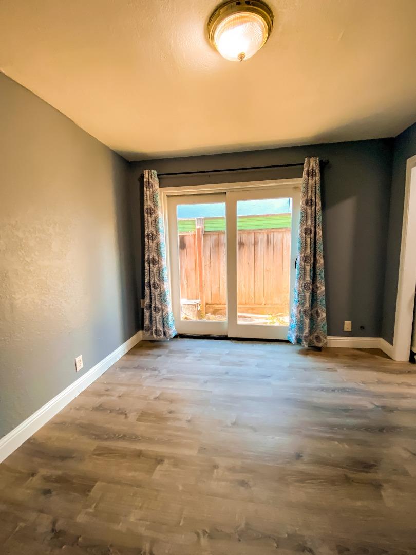 6152 Baker Street Oakland, CA 94608 - Photo 20 of 23 a view of an empty room with wooden floor and a window