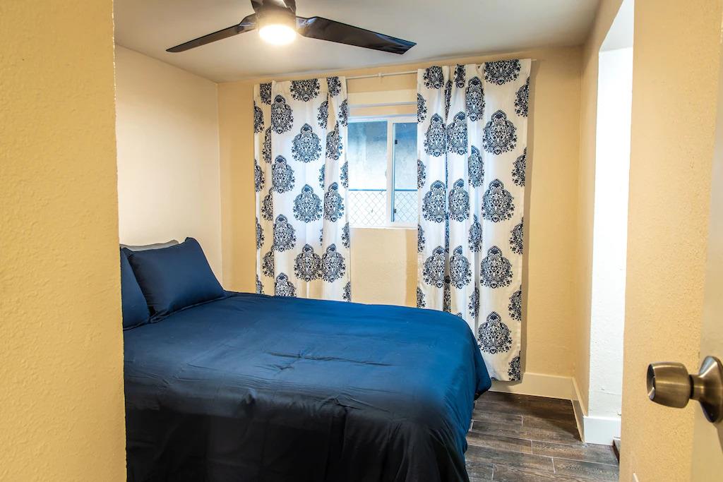 6152 Baker Street Oakland, CA 94608 - Photo 8 of 23 a bed sitting in a bedroom next to a bathroom