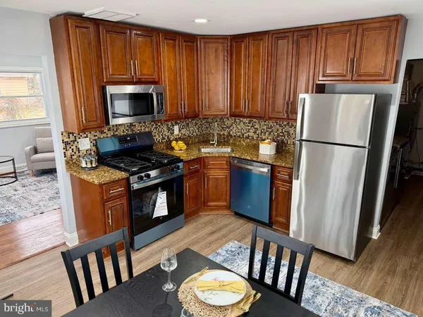 a kitchen with stainless steel appliances granite countertop a refrigerator stove top oven and sink