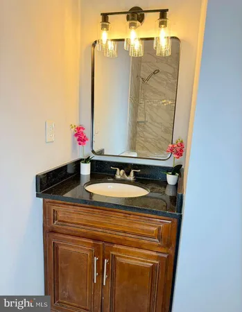 a bathroom with a granite countertop sink and a mirror