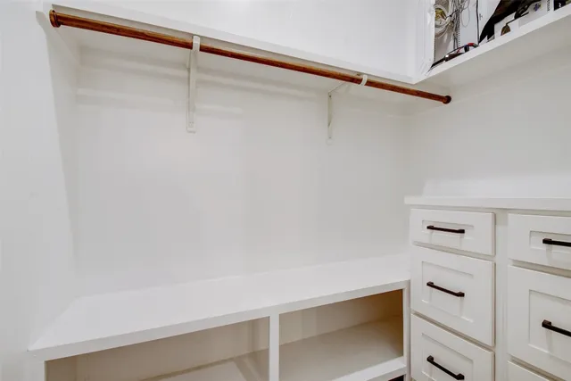 an empty room with window and ceiling fan