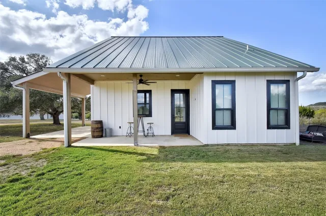a view of a house with a yard and large tree
