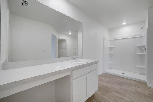 an empty room with wooden floor and mirror