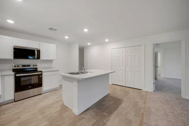 a kitchen with a sink stove and cabinets