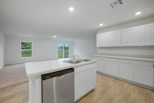 a kitchen with kitchen island a sink stove top oven and cabinets