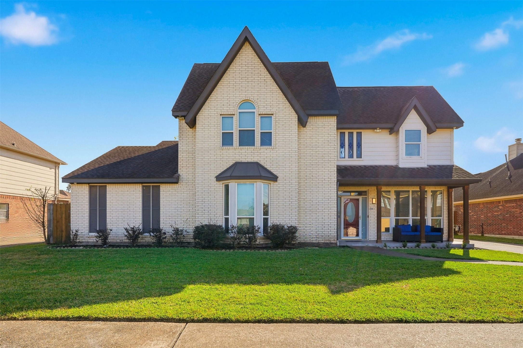 a front view of a house with a yard and trees