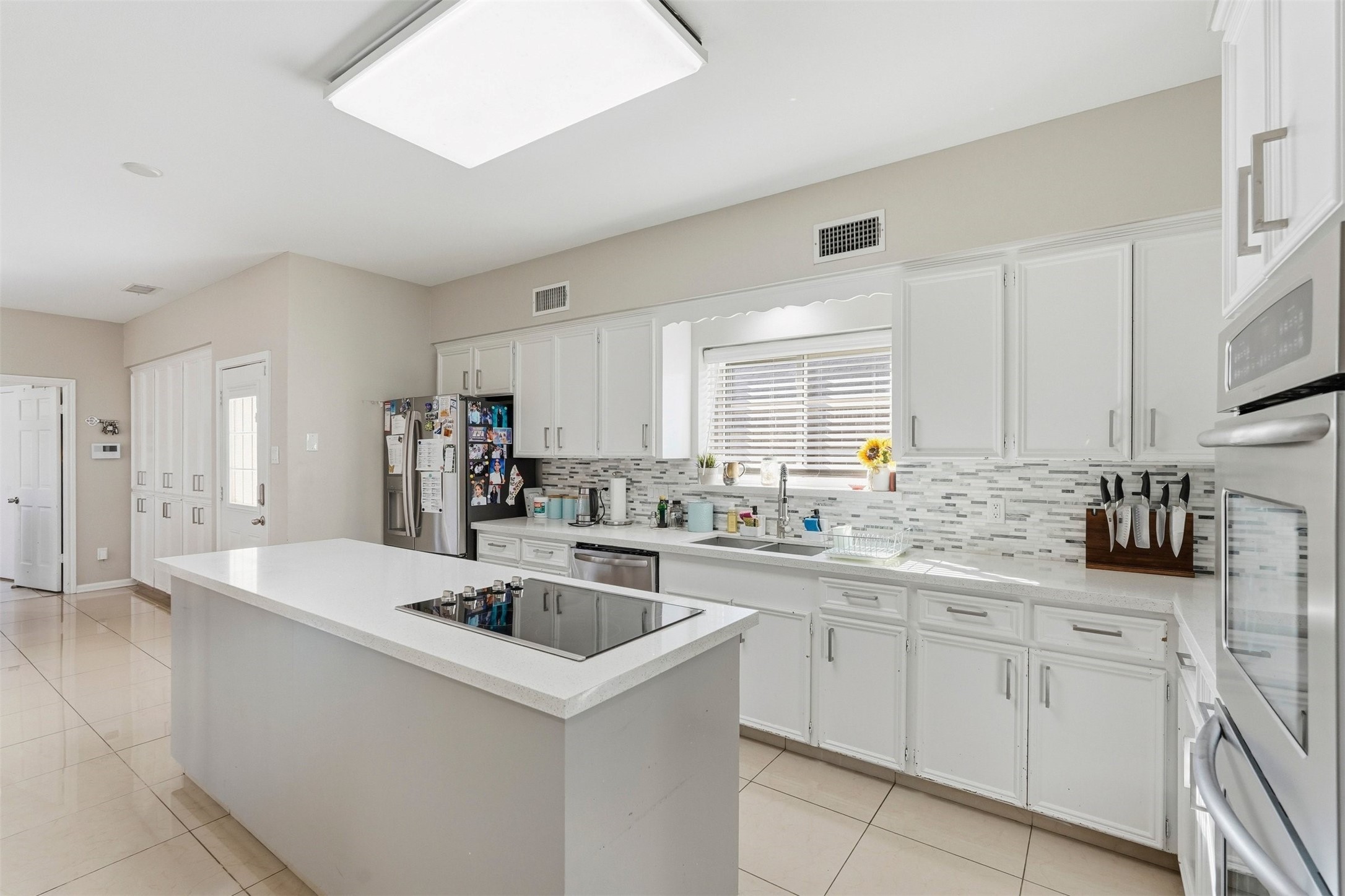7927 Wolfield Lane Houston, TX 77071 - Photo 7 of 24 a kitchen with granite countertop a sink and white cabinets
