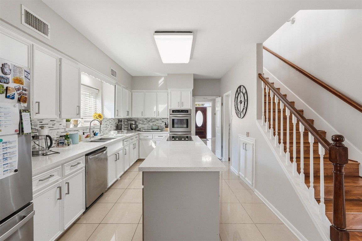 7927 Wolfield Lane Houston, TX 77071 - Photo 9 of 24 a large white kitchen with stainless steel appliances lots of counter space and windows
