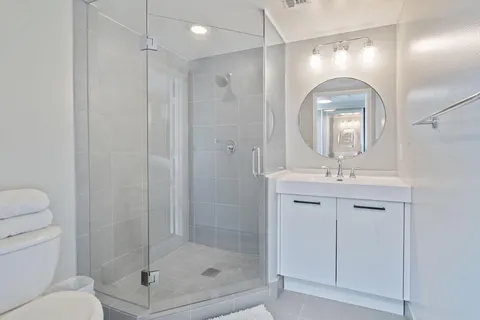 a bathroom with a shower a sink and mirror
