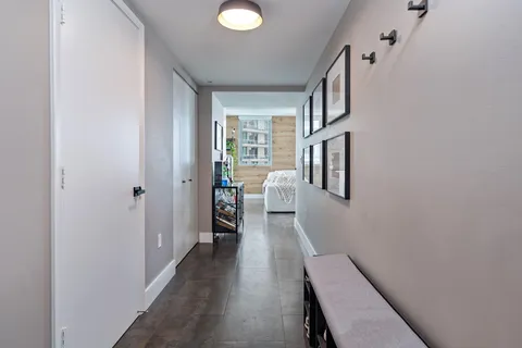 a hallway with wooden floor and cabinet