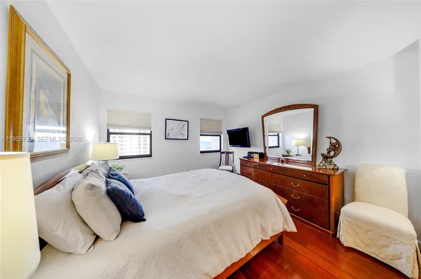 a bedroom with a bed and a dresser with mirror