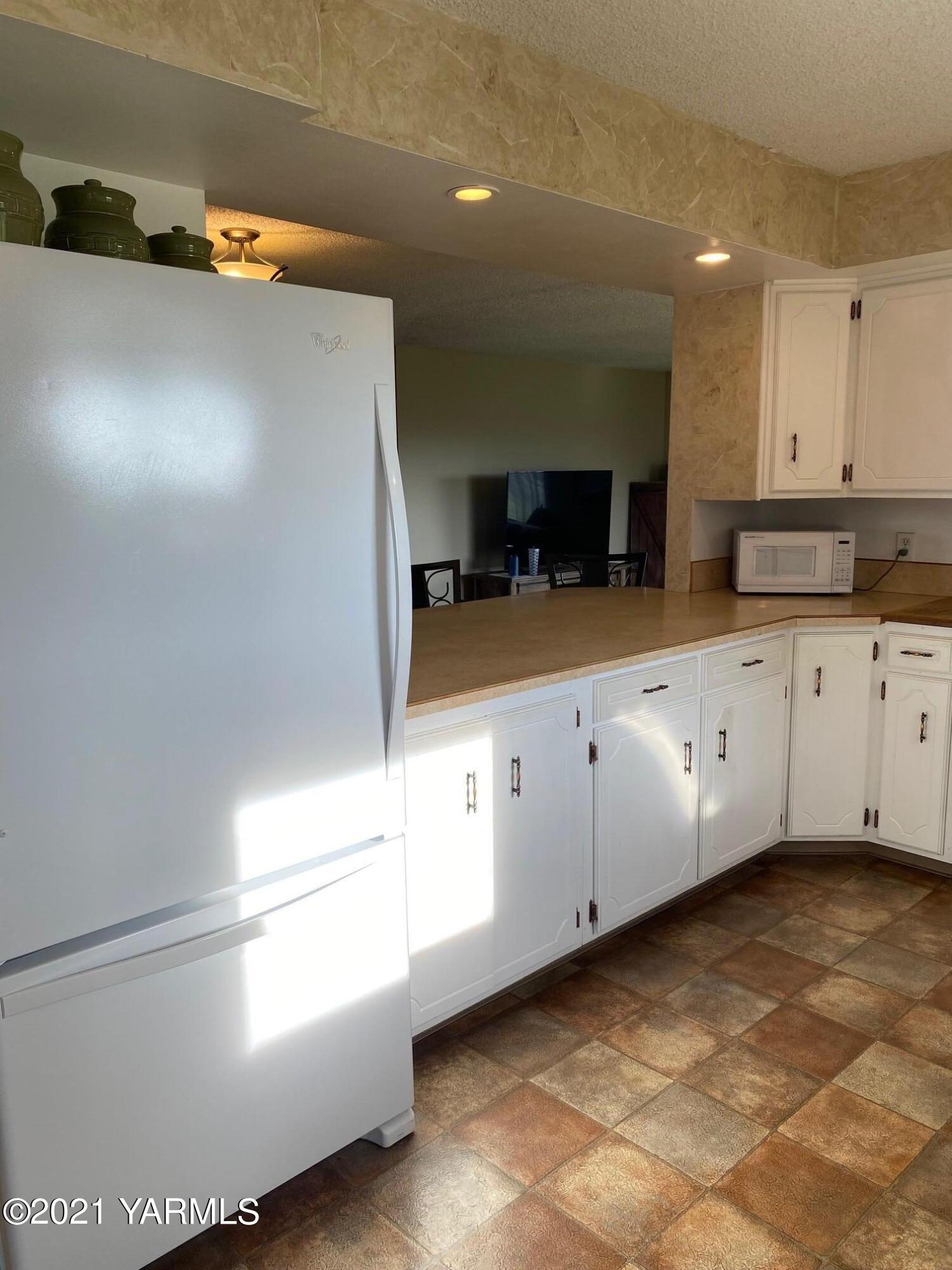 320 Bliss Road Zillah, WA 98953 - Photo 7 of 33 a kitchen with granite countertop white cabinets and white appliances