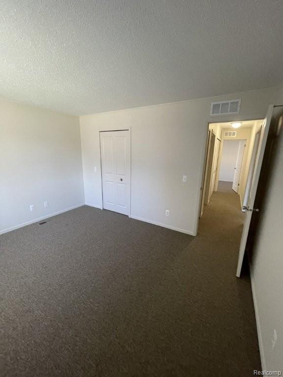 35775 Union Lake Road Clinton Township, MI 48035 - Photo 26 of 30 Unfurnished bedroom featuring dark colored carpet, a textured ceiling, and a closet