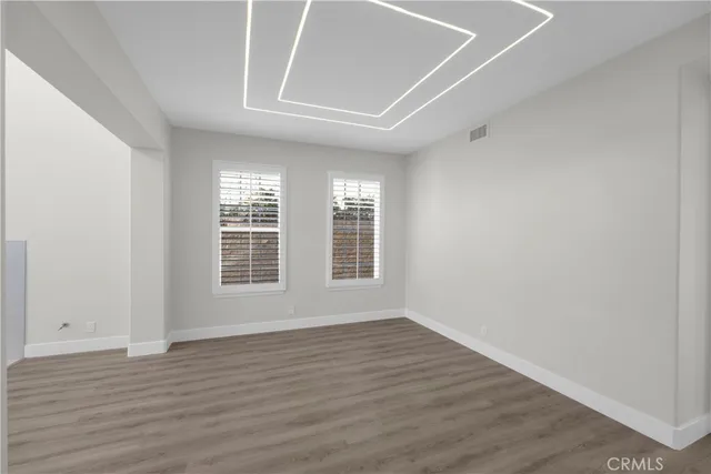 an empty room with wooden floor and a fireplace