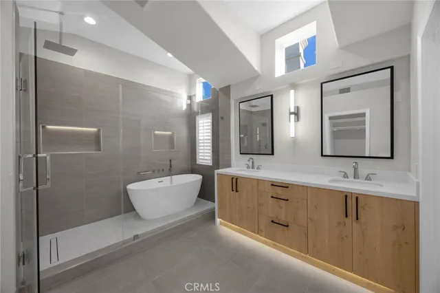 a bathroom with a granite countertop sink a toilet a mirror and bathtub