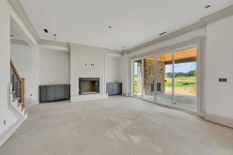 a view of an empty room with a fireplace and a large window