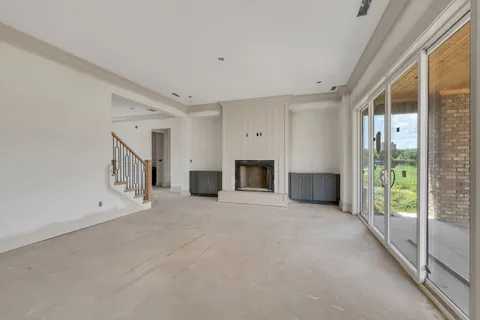 a view of an empty room with a fireplace and a window