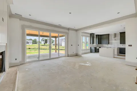 a view of an empty room with a window and fire place
