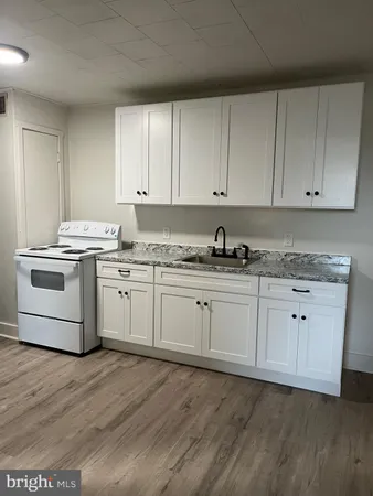 a kitchen with granite countertop white cabinets and white appliances