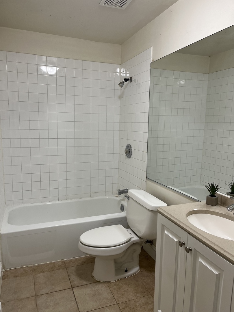Undisclosed Address Hanover Park, IL 60133 - Photo 10 of 10 a bathroom with a sink a toilet and a bathtub