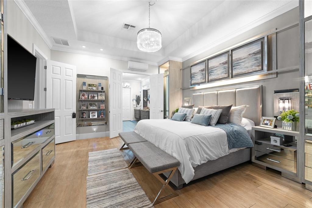 6001 Caymus Loop Windermere, FL 34786 - Photo 20 of 44 a spacious bedroom with a bed a flat screen tv and a book shelf