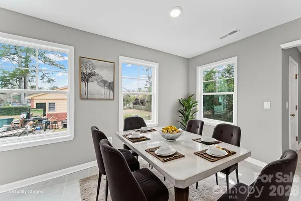 a view of a dining room with furniture a rug and wooden floor