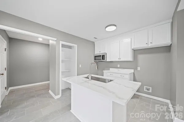 a kitchen with kitchen island a sink appliances and cabinets