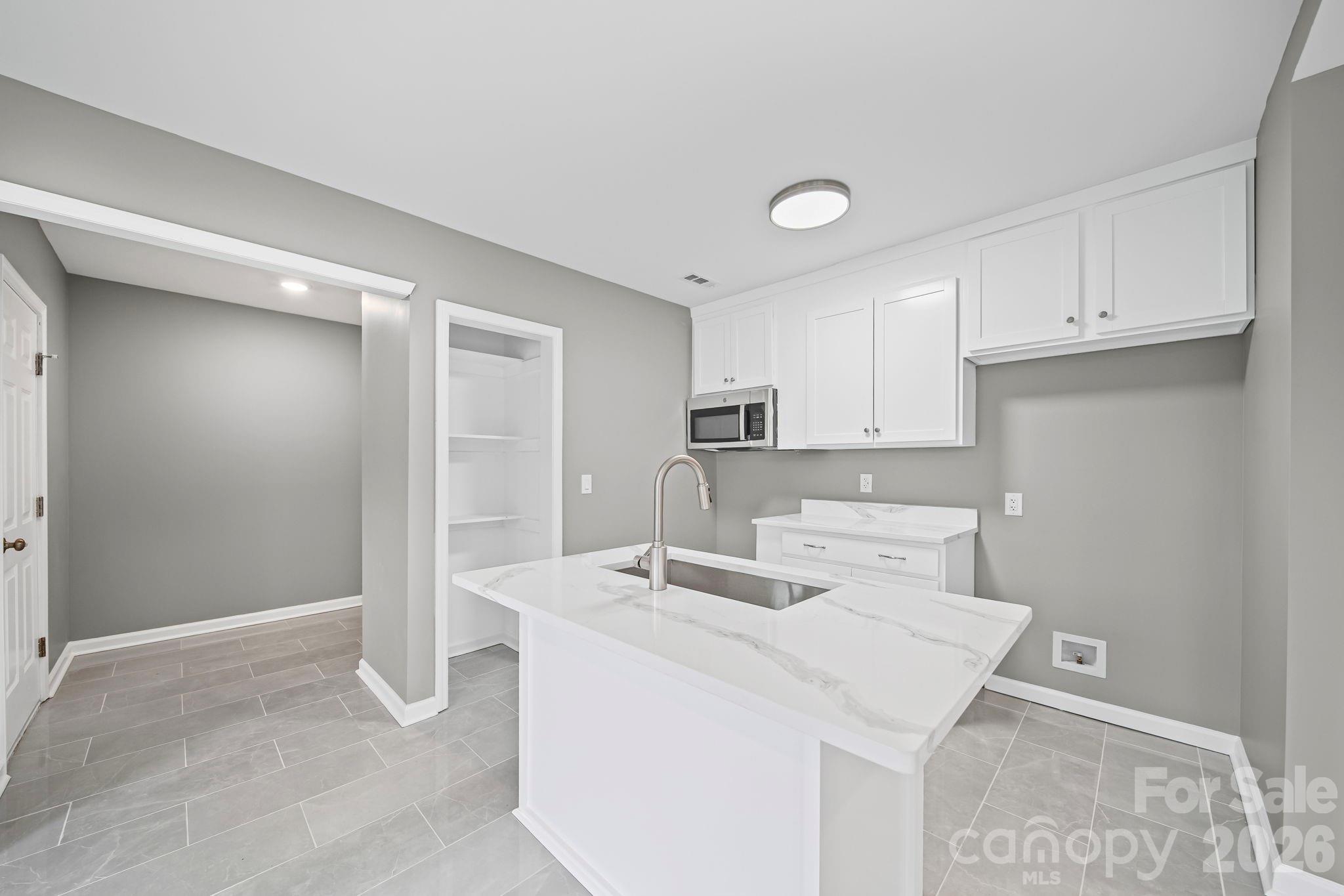 4913 Jones Street, Unit 12 Columbia, SC 29203 - Photo 4 of 17 a kitchen with kitchen island a sink appliances and cabinets