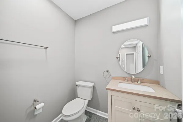 a bathroom with a granite countertop toilet sink and mirror