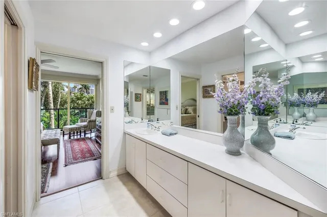 a bathroom with a sink a large mirror and a potted plant