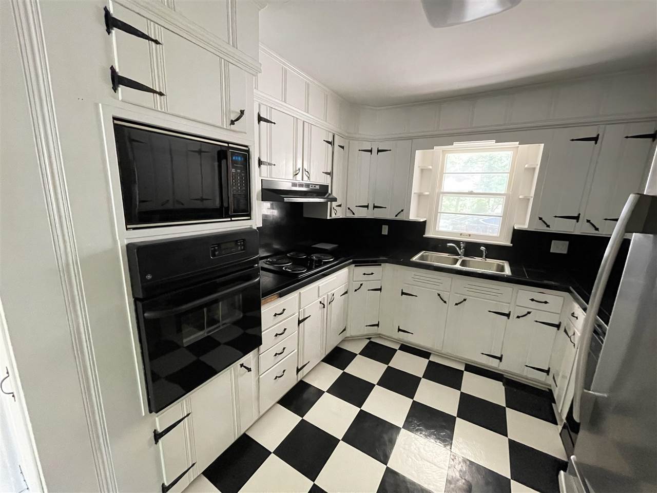 256 Thompson Drive Ripley, TN 38063 - Photo 12 of 17 a kitchen with granite countertop white cabinets and black appliances