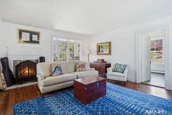 a living room with furniture a rug a window and a fireplace
