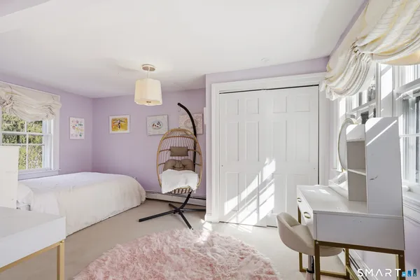 a bedroom with a bed a chair and a chandelier