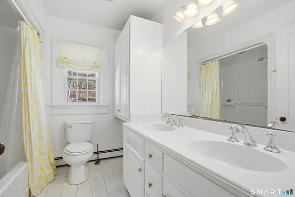 a bathroom with a toilet a sink and mirror