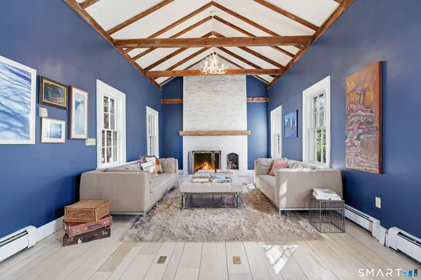 a living room with furniture a fireplace and large windows