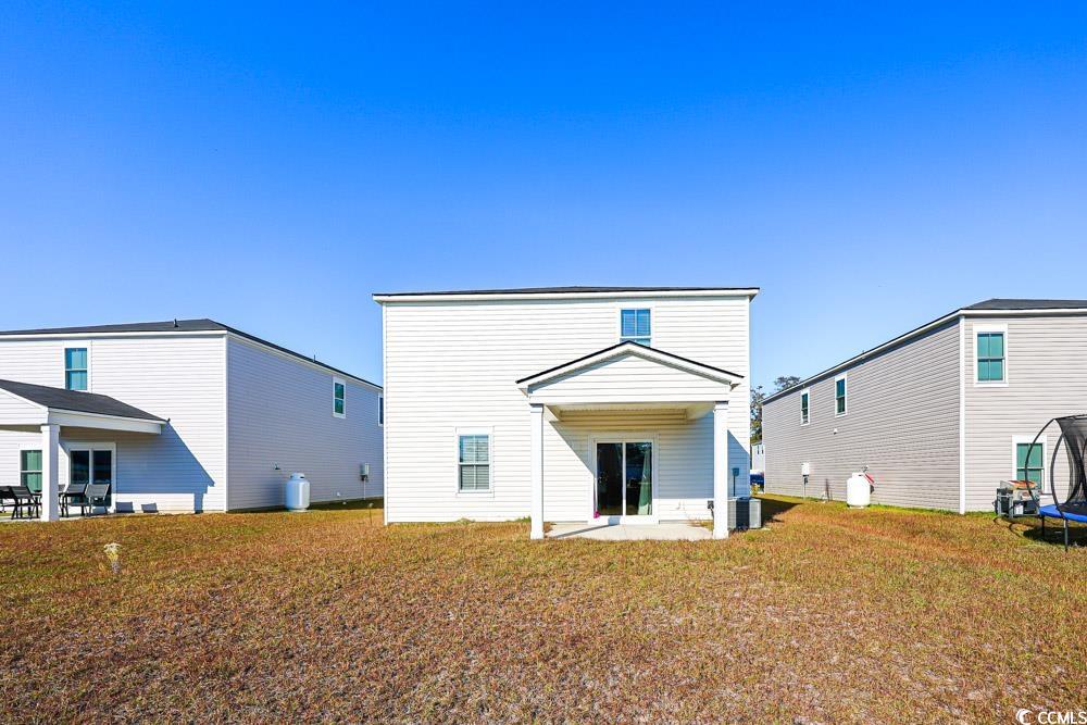 1560 Swing Bridge Way Myrtle Beach, SC 29588 - Photo 28 of 35 Rear view of house featuring a patio, a trampoline, and a yard