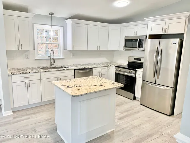a kitchen with white cabinets sink and refrigerator