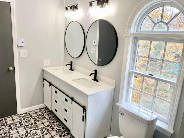 a bathroom with a sink a mirror a vanity and a window
