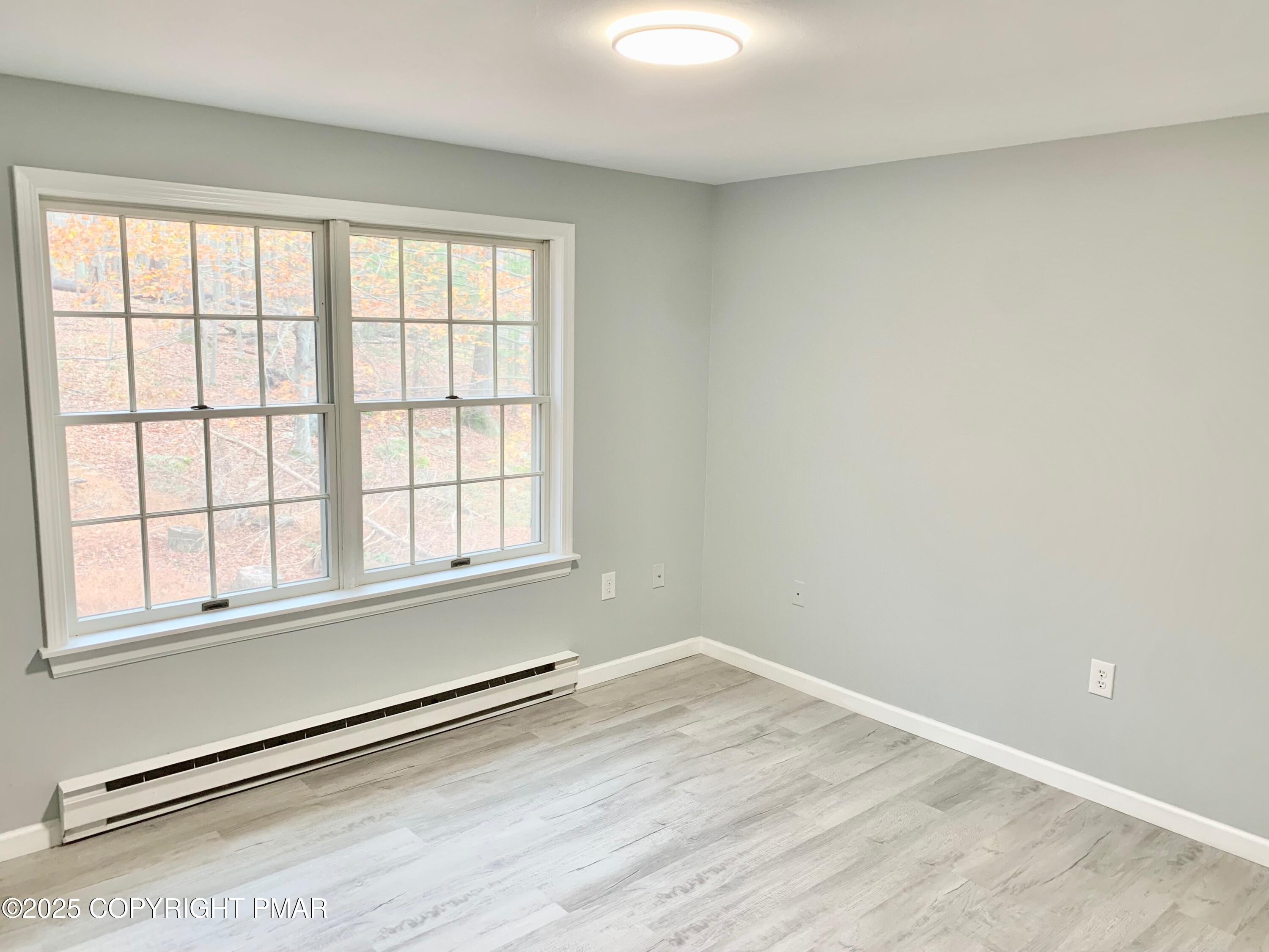 111 Lake In The Clouds Road Canadensis, PA 18325 - Photo 24 of 39 an empty room with wooden floor and windows