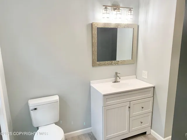 a bathroom with a toilet sink and mirror