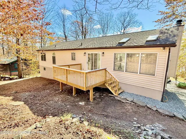 a view of a house with a yard and deck area