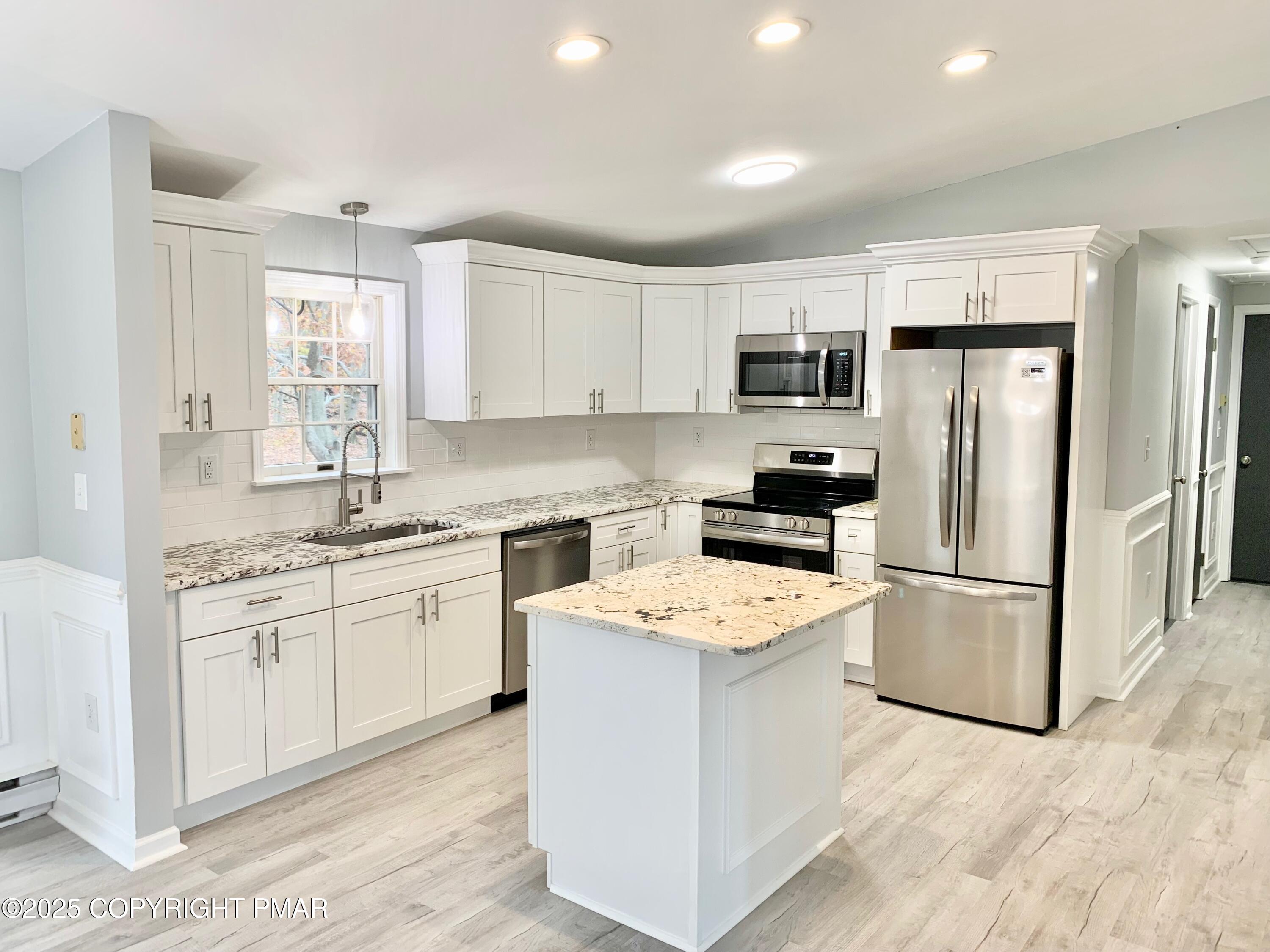 111 Lake In The Clouds Road Canadensis, PA 18325 - Photo 9 of 39 a kitchen with a refrigerator a stove top oven a sink and cabinets