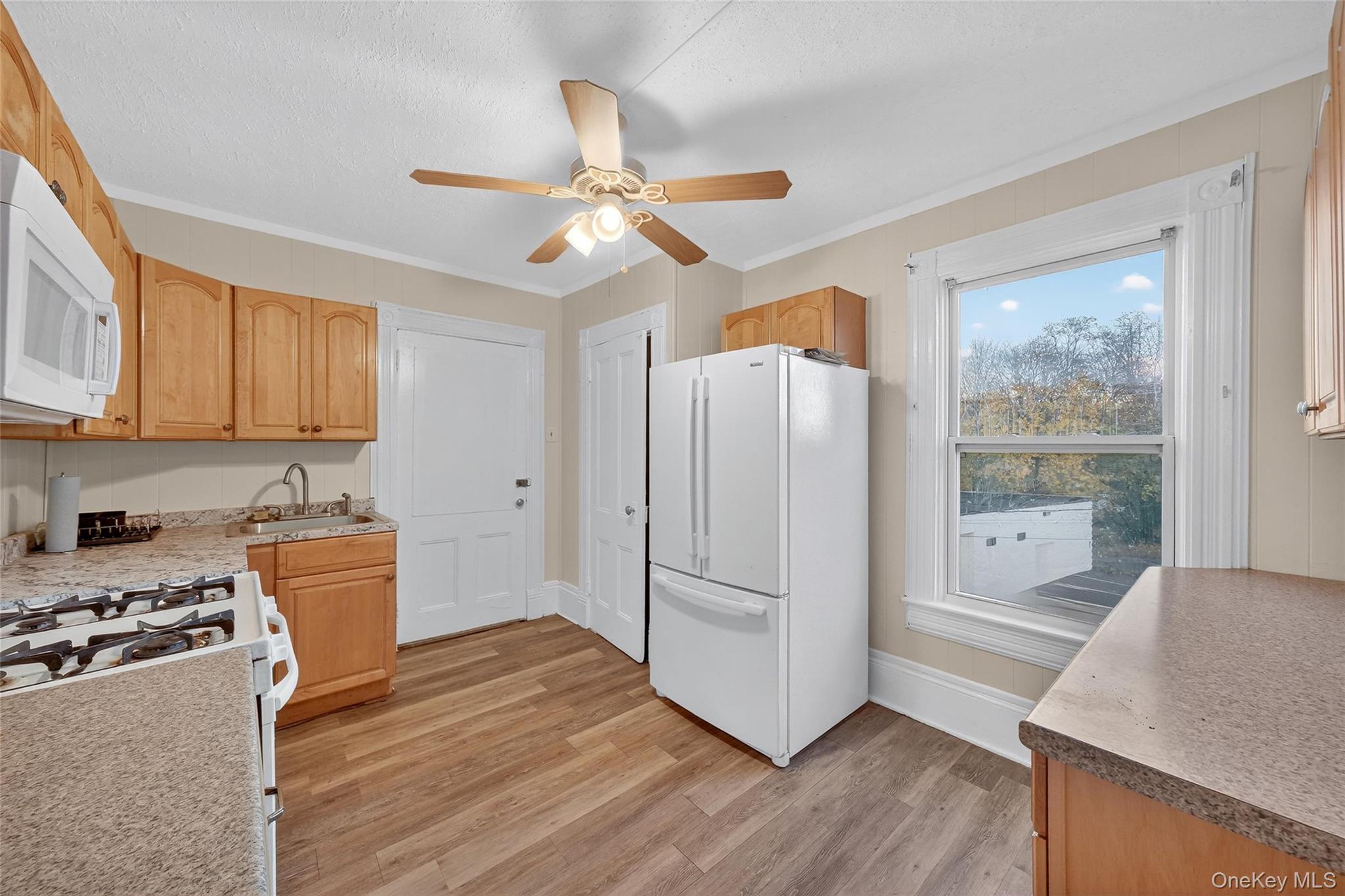 11 Zimmer Avenue, Unit 2 Poughkeepsie, NY 12601 - Photo 11 of 27 a kitchen with a refrigerator a stove top oven and a wooden floor
