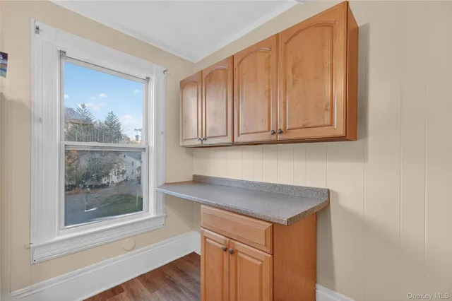 a view of a sink a microwave and cabinets