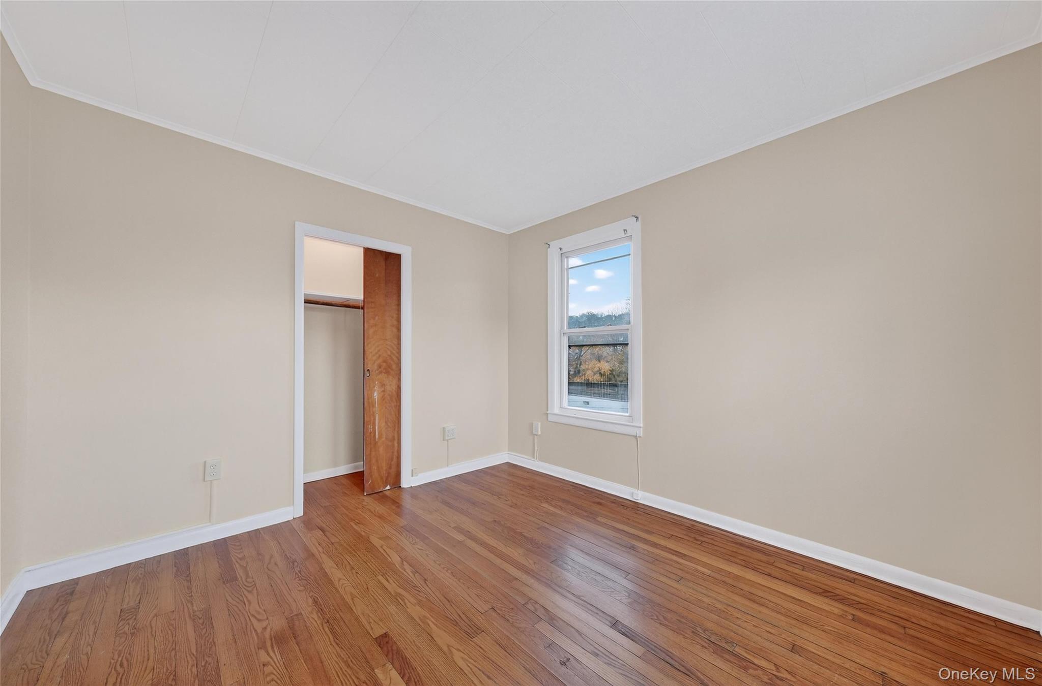 11 Zimmer Avenue, Unit 2 Poughkeepsie, NY 12601 - Photo 19 of 27 an empty room with wooden floor and windows
