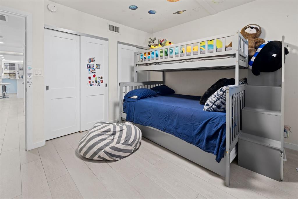 3100 Northeast 49th Street, Unit 206 Fort Lauderdale, FL 33308 - Photo 22 of 39 a bedroom with a bed and a white wooden cabinets