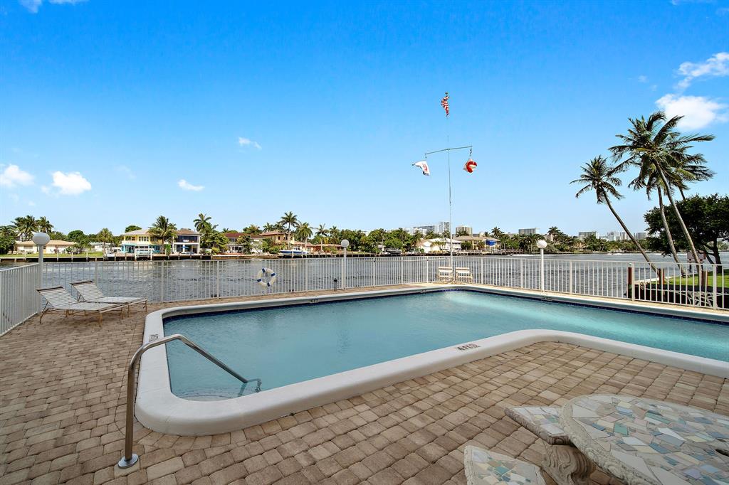 3100 Northeast 49th Street, Unit 206 Fort Lauderdale, FL 33308 - Photo 35 of 39 a view of a swimming pool and an outdoor seating