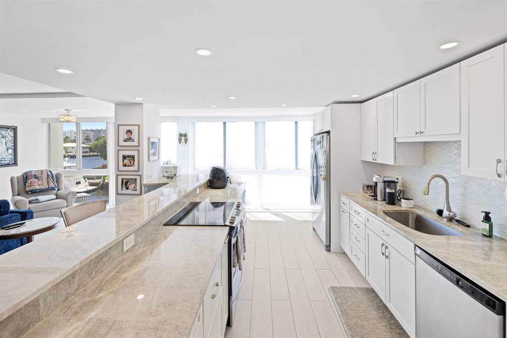 3100 Northeast 49th Street, Unit 206 Fort Lauderdale, FL 33308 - Photo 5 of 39 a kitchen with stainless steel appliances granite countertop a refrigerator and a sink